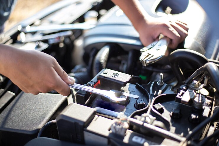 Individual working on a car engine with a wrench, concentrating on the ignition lock repair.