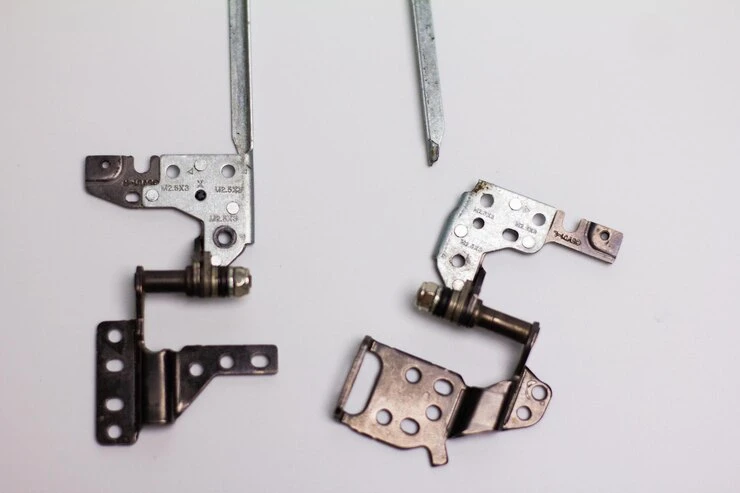 Two metal continuous hinges pieces with screws and a screwdriver