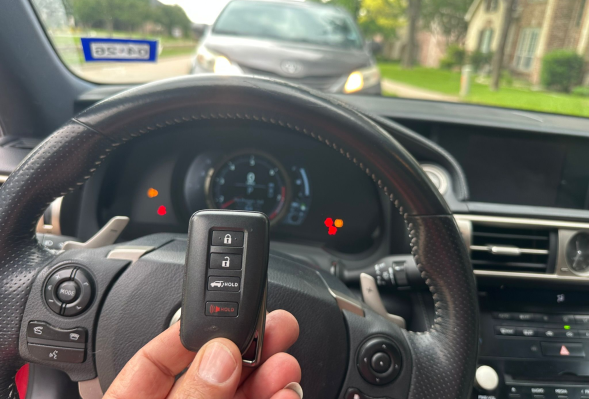A person holding a car key fob in their hand